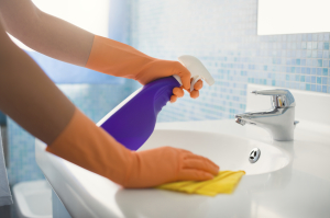 woman doing chores cleaning bathroom at home