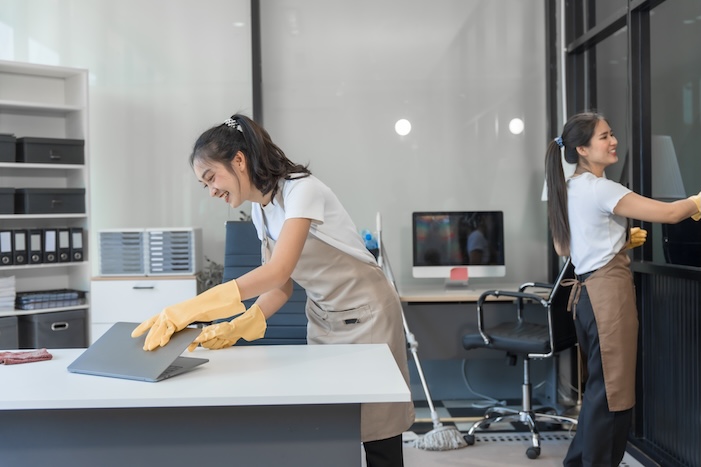 two asian housekeepers wear overalls and work together efficiently to clean the living room, study